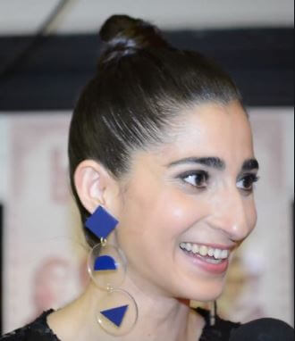 Alba Flores wearing blue long hook earrings.